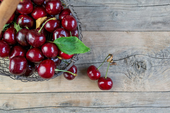 Fresh ripe cherries in a basket on wooden background. Copy spase