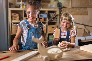 Fototapeta premium Two young girls doing woodwork in a workshop 