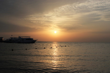 Fototapeta na wymiar Suset on the sea. Boats on the water. Warm rays of sun light.