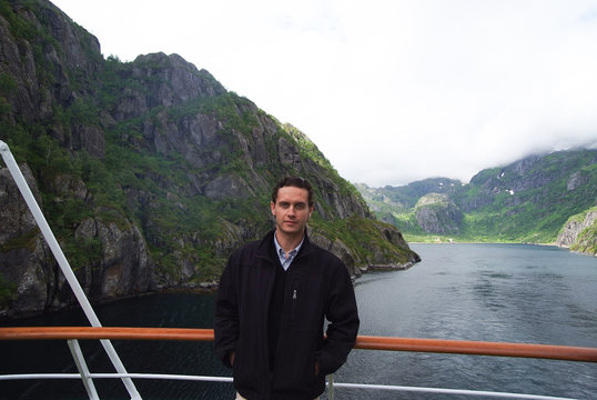 Norway fjord mountain landscape with man tourist on cruise ship. Norway cruise vacation travel. Explore Norway. List of best parks and nature attractions. Journey through undisturbed nature