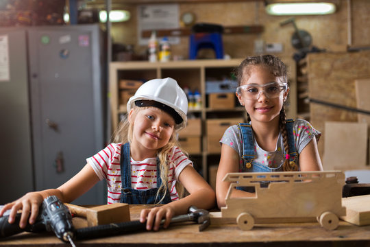 Two young girls doing woodwork in a workshop
