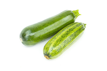 Two whole fresh green ripe zucchini or courgettes, object isolated on white background