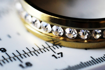 Gold ring with diamonds and a measuring instrument, the value of jewelry, macro