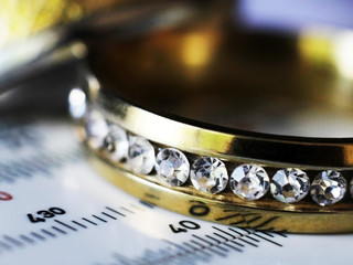 Gold ring with diamonds and a measuring instrument, macro