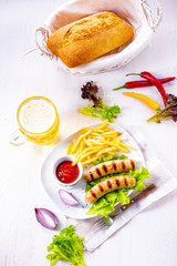 grilled bratwurst with chips and cold beer