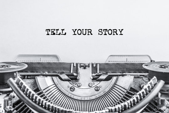 TELL YOUR STORY Text Typed On A Vintage Typewriter, Old Paper, Close-up. History