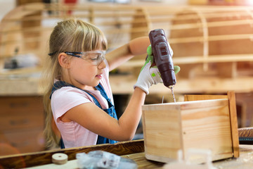 Young girl doing woodwork in a workshop
