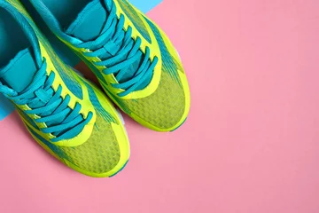 Selbstklebende Fototapeten Pair of sport shoes on colorful background. New sneakers on pink and blue pastel background, copy space. Overhead shot of running shoes. Top view, flat lay © mirage_studio