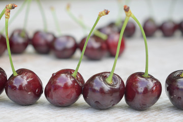 Spelled cherries on the white wooden background