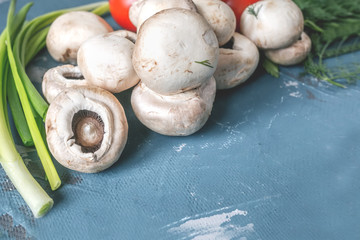 Fresh mushrooms and vegetables with herbs. Wooden background, close-up.