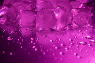 A pile of ice cubes in purple on a reflecting table