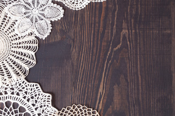 Vintage knitted lace on the background of wooden boards. - obrazy, fototapety, plakaty