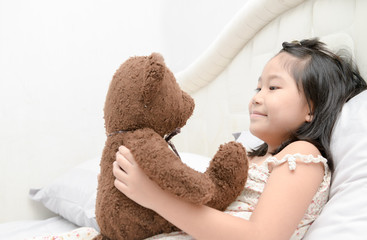 Cute girl is playing with a teddy bear