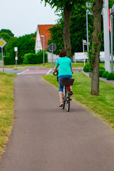 Naklejka premium Young woman riding a bike, back view