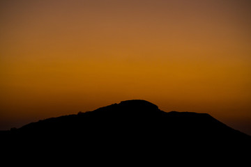 landscape of a sunrise with silhouette mountains