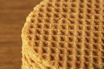 Wafers stacked in a pyramid on a wooden table. Macro. Copy space.