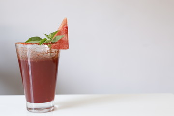 watermelon drink with a cut watermelon and mint leaf