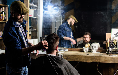 Reflexion of barber styling hair of bearded client with comb. Hipster client getting hairstyle....