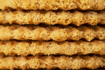 Wafers stacked in a pyramid on a wooden table. Macro. Copy space.