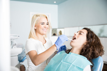 Obraz na płótnie Canvas Female dentist examiming a patient
