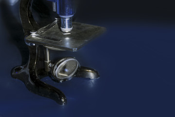 old microscope close-up, image on a blue background