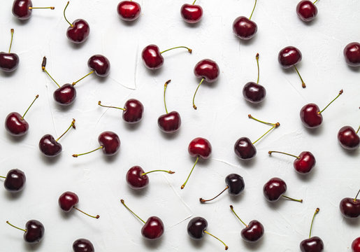 Flat background: Fresh ripe red Cherry is evenly spread out on a white background.