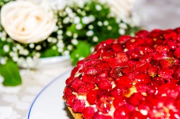 strawberry cake with flowers in the background