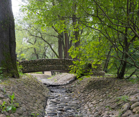 Stream in a stone bed. A stone bridge