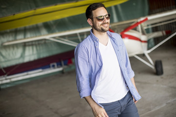 Young man in the airplane hangar