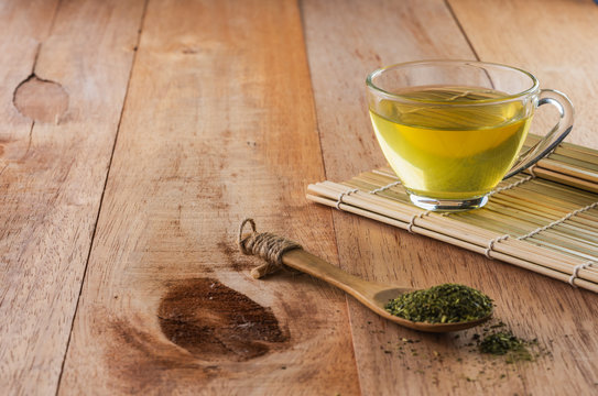 a cup of green tea on bamboo