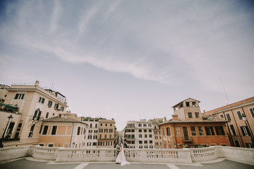 Fototapeta premium Young newly married couple posing in Rome with beautiful and ancient architecture in the background