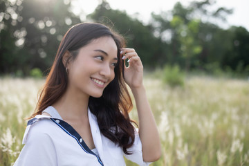 Asian women happy smile on relaxing time at the meadow and grass