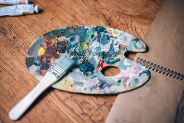  palette of the artist on a wooden table with oil paints.