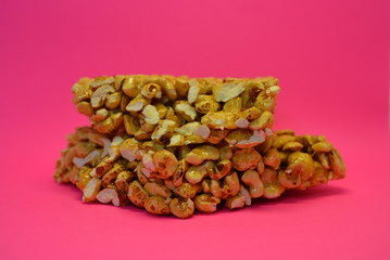On a bright colorful pink paper background is located and placed from a delicious and sweet grilling of air corn kernels, popcorn with caramel