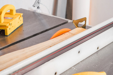 Cutting the board on a circular saw in a woodworking workshop