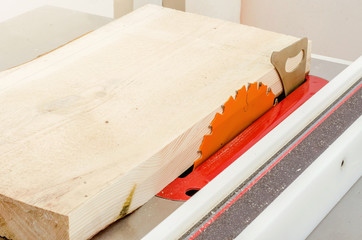 Cutting the board on a circular saw in a woodworking workshop