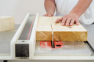 Woodworking, a man cutting a board on a circular saw machine