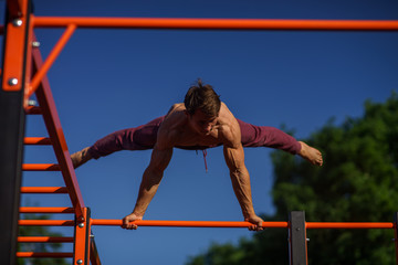 Fototapeta premium Muscular man making planche on the street. Street workout