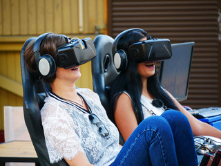 Two girls play  a virtual game in virtual hats. Virtual reality. Virtual games.