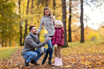 Fototapeta premium family, season and people concept - happy mother, father and little daughter with maple leaf at autumn park