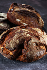 Different kinds of bread and bread rolls on board from above. Kitchen or bakery