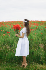 Beautiful woman in field with a lot of poppy flowers