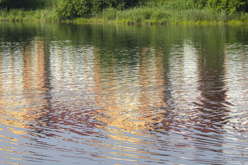 Reflection of the brick building on the shores of lake