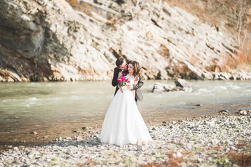 Wedding couple, groom and bride hugging, outdoor near river