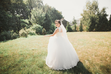 Beautiful bride spinning with perfect dress in the park