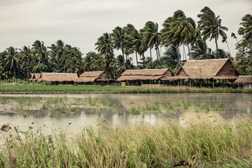 tropical landscape with lake and traditional thai houses