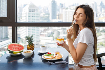 Young woman eating breakfast at morning