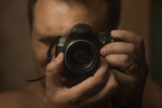 a man with a camera in the mirror
