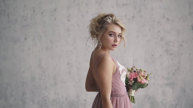 portrait of a young girl in an evening gown. evening make-up and a beautiful hairstyle. charming blonde in a dress with an open back