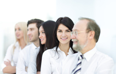 Fototapeta premium Close-up portrait of executive business people standing in a row at office and looking at the camera.